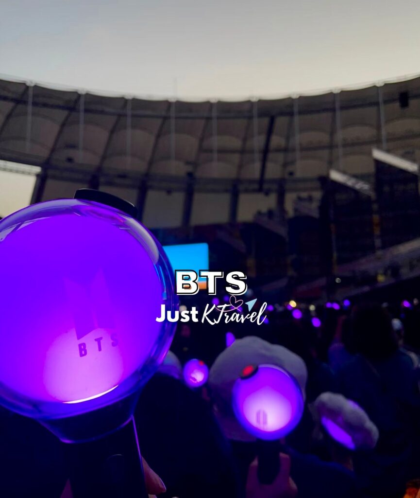 Crowd at BTS concert in Busan stadium with light sticks and stage view