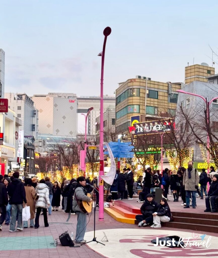 Busking performance on Hongdae shopping street with restaurants and visitors in Seoul