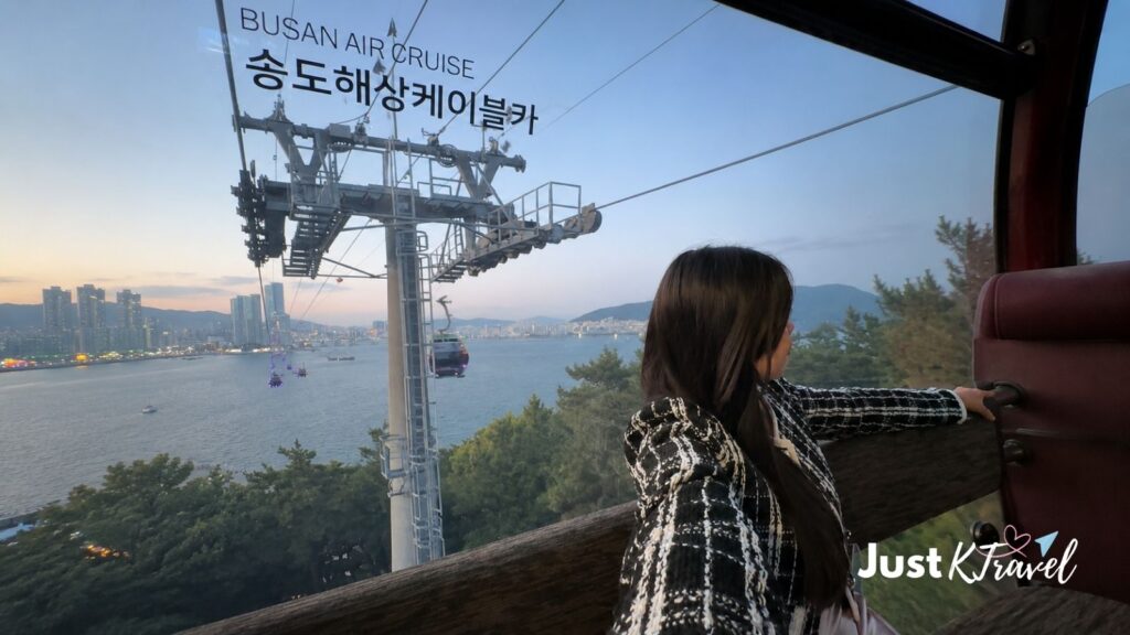 Woman inside Songdo Cable Car overlooking Busan at night