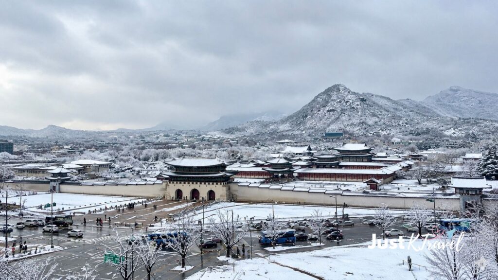 Snow-covered Gyeongbokgung Palace with mountains in the background in Seoul, South Korea